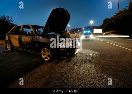 Auto von der Polizei in den frühen Stunden des Morgens besucht ausgebrannt Stockfoto