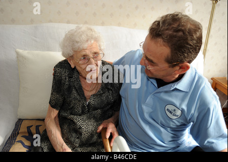Eine ältere Dame teilt einen Witz mit einem Homecare-Mann aus dem Rat. Stockfoto