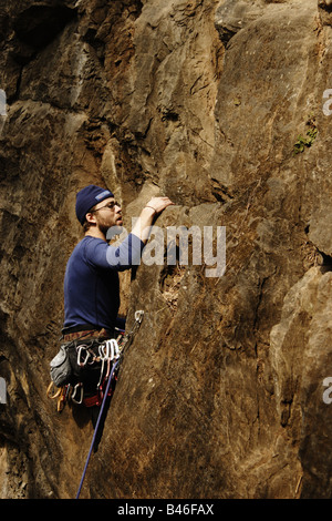 Junger Mann klettert in der Nähe von senkrechten Felswand in Nepal Stockfoto