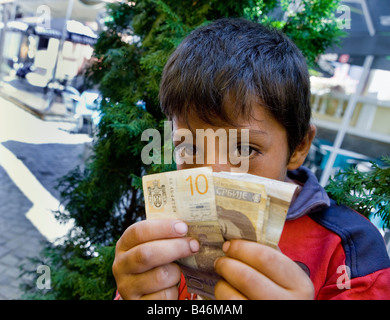 Roma oder Zigeuner junge Bettler in den Straßen von Nis Serbien mit etwas von dem Geld sammelte er durch Betteln Stockfoto