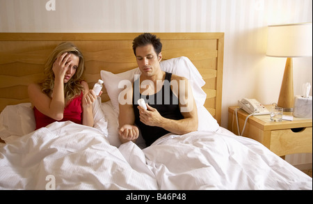 Paar im Bett, Frau, die Einnahme von Pillen Stockfoto