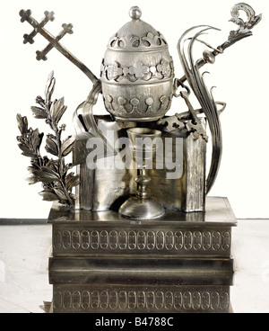 Papst PiusII. - ein silberner Schreibsatz., Box mit seitlichen Griffen, vor dem päpstlichen Wappen, also der Taube des Friedens, die einen Olivenzweig in seinem Schnabel trägt und auf einem drei gehillten Berg, unter einem Balken und fließendem Wasser sitzt. Umrankt ist es das Motto "Opus Justitae Pax" von Papst Paul XII (Das Werk der Gerechtigkeit ist Frieden, Is, 32, 17). Auf einem Sockel im Rücken befindet sich der päpstliche Tiara, der von Kreuz und Krosier flankiert wird und auf der Heiligen Schrift und dem Kelch steht, der von Lorbeer und Palmblättern umrahmt wird. Daneben befinden sich eine abnehmbare Tintenmulde und ein Sandbehälter. W, Stockfoto