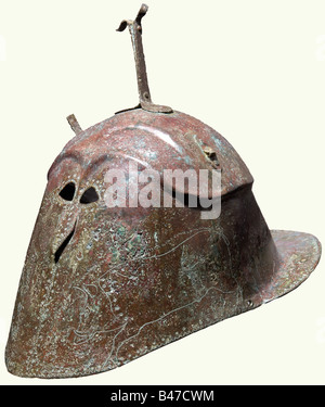 Ein Bronze-Helm vom apulianisch-korinthischen Typ, Süditalien, erste Hälfte des 5. Jahrhunderts vor Christus In einem Stück aus Blechbronze, die obere Hälfte getrennt und etwas breiter als die Seiten durch einen extrudierten Grat. Oben eine bronzene Gabel und die Überreste von zwei seitlichen Haltern, die Stirn mit zwei Reihen sehr hoher Bogenrippen über extrem kleine mandelförmige Augenschlitze, darunter eine kleine und leicht hervorstehende "Nase". Die Wangen, auf jeder Seite mit einem großen und sehr anmutigen, gut gezeichneten Eber eingraviert, die Umfassungen der Augen, der Nase und des Hels, Stockfoto