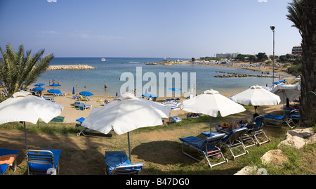 ANSICHT VON PERNERA BEACH IN DER NÄHE VON PARALIMNI, PROTARAS, ZYPERN MIT SONNENSCHIRMEN UND GOLDENEM SAND Stockfoto