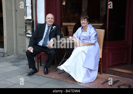 Braut und ihr Bruder mit einer Zigarette saß vor einem Restaurant in Islington, Nordlondon. Stockfoto