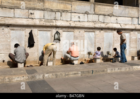 Männer, die Reinigung vor dem Gebet außerhalb der Yeni Cami Eminönü Istanbul Türkei Stockfoto