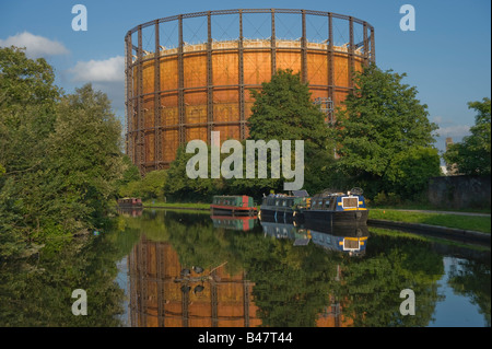 Ein malerischer Blick auf einen alten Gashalter, der sich im Wasser spiegelt und vom Grand Union Canal in West London aus gesehen wird. UK. Stockfoto