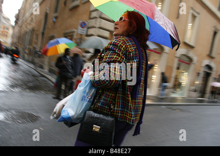 Shopper im Regen auf der via Condotti Straße Straße in Rom, Italien Stockfoto