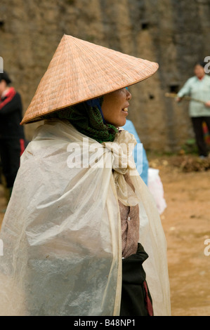 Profil einer Frau mit einem Bambus konische Hut und Plastikfolie zu halten off der Regen Muong Khuong Vietnam Stockfoto