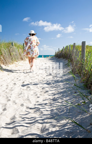 Eine Frau, einen Sandstrand Weg Stockfoto