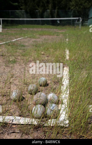 Haufen von zerlumpten Tennisbälle auf eine vernachlässigte Sandplatz Stockfoto