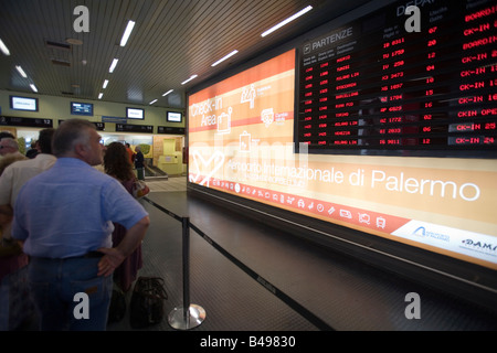 Passagiere, die Überprüfung Flugplan auf Abfahrtstafel Falcone Borsellino Flughafen, Palermo, Italien. Stockfoto