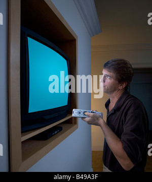 Ein mittlerer gealterter Mann sehr ist nah an den TV und beobachten aber enttäuscht ein Pfad für den Bildschirm ist im Preis inbegriffen Stockfoto