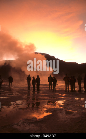 Touristen besuchen ein Fumarole im Geysirfeld El Tatio bei Sonnenaufgang, in der Nähe von San Pedro de Atacama, Chile Stockfoto