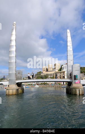 Die Fußgängerbrücke über den Eingang zum Innenhafen in Torquay an einem hellen sonnigen Abend Stockfoto