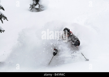 Ein Skifahrer im Tiefschnee mit einem großen Gesicht geschossen von Schnee Stockfoto