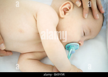 Mutter streicheln beschnitten Ansicht schlafen Babys Kopf, Stockfoto