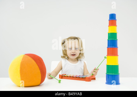 Kleinkind Mädchen sitzen mit Spielzeug, spielen Xylophon, lächelnd in die Kamera Stockfoto