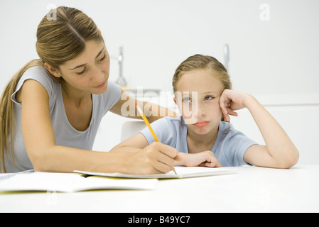 Mutter Tochter helfen bei den Hausaufgaben, Mädchen wegsehen und schmollt Stockfoto