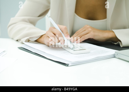 Berufstätige Frau mit Taschenrechner, beschnitten Ansicht Stockfoto