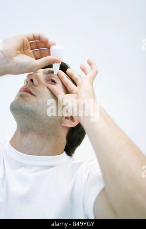 Mann Anwendung Auge Tropfen, Kopf nach hinten Stockfoto