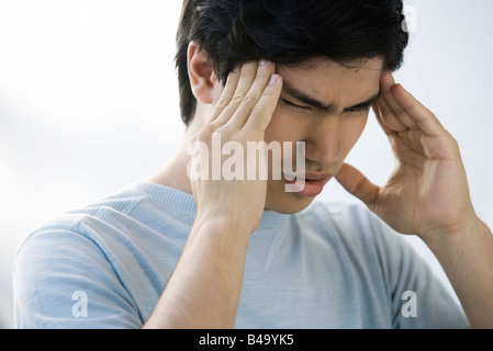 Mann massiert Tempel, Augen geschlossen Stockfoto
