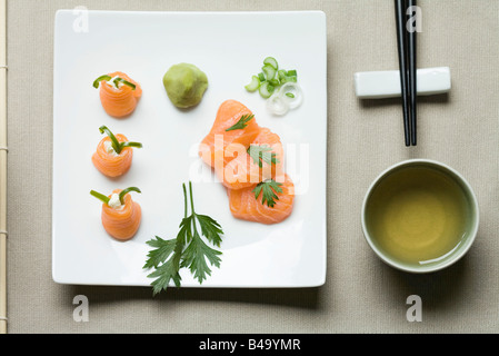 Verschiedene Sushi auf große Sushi Platte mit Tee und Stäbchen neben angeordnet Stockfoto