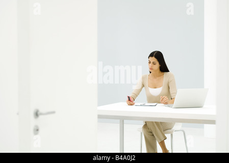 Geschäftsfrau, die allein im leeren Büro arbeiten Stockfoto
