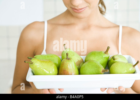 Frau hält Teller mit grünen Birnen, Nahaufnahme Stockfoto