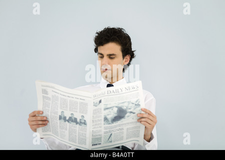 Junger Mann Lesung Wirtschaftszeitung Stockfoto