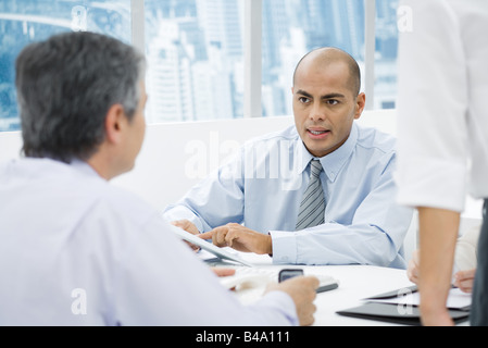 Geschäftsleute, die mit einem Treffen am Schreibtisch, konzentrieren sich auf den Mann im Hintergrund Stockfoto