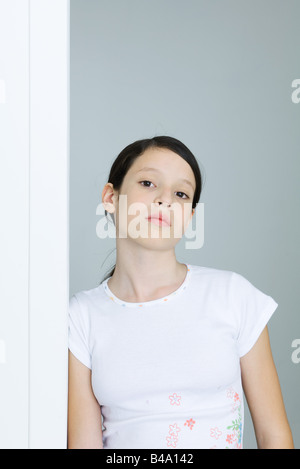 Preteen Mädchen lehnte sich gegen die Tür, Blick in die Kamera Stockfoto