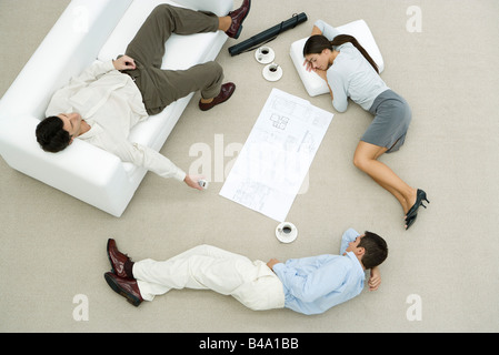 Team von Fachleuten Nickerchen auf Boden und Sofa, auf dem Boden zwischen Ihnen, obenliegende Ansicht Blaupause Stockfoto