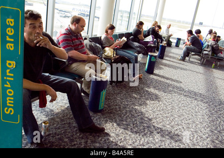 Menschen mit einer Zigarette bei designeted Raucherbereich am Flughafen Stansted London UK Stockfoto