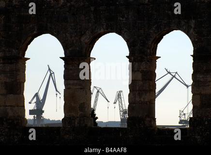 Hafenkrane gesehen durch Bögen der alten römischen Amphitheater Arena in Pula Istrien Kroatien Stockfoto