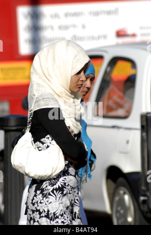 Muslimische Frauen warten darauf, überqueren Sie die Straße In Whitechapel, London. Stockfoto