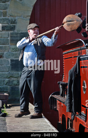 Stoker Ausfüllen einer Dampfmaschine zart mit Kohle an die Beamish Open Air Museum in County Durham, England Stockfoto