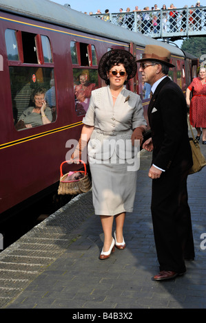 Mann und Frau gekleidet auf 1940 s Kleidung auf Bahnhof Bahnsteig an der Weybourne Norfolk in England Stockfoto