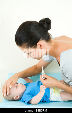 Frau des Säuglings Temperaturmessung Stockfoto