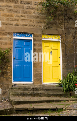 Angrenzende Türen lackiert, hellblau und gelb an Robin Hoods Bay North Yorkshire England Stockfoto