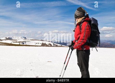 Weibliche Wanderer in rote Jacke steht in der Nähe Gipfel des Cairn man in den Cairngorm Mountains, Schottland Stockfoto