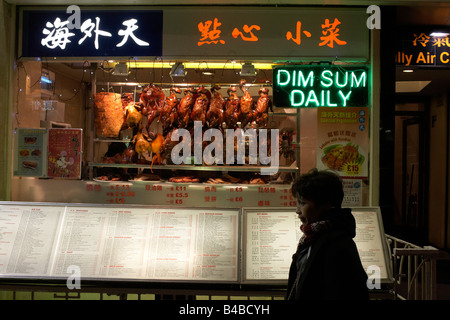 Ein Passant steht vor einem chinesischen Restaurant Dim Sum in Chinatown Londons ethnische chinesische Gemeinschaft Zuhause bietet. Stockfoto