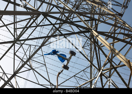 Des Kindes verworrenen Dreirad hängt in den Stacheldraht ein Strommast auf einem Landgut in Beckton, East London Stockfoto