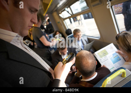 Stehende Hauptverkehrszeit Bahn Pendler überprüft E-mail an Bord Kutschen Reisen in London Hauptbahnhof Stockfoto