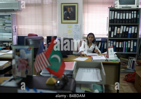 Arbeitnehmerin Cyprea Marine Lebensmittel arbeitet unter Porträt der Malediven Ex-Präsident Gayoom in der Hauptstadt Malé Stockfoto