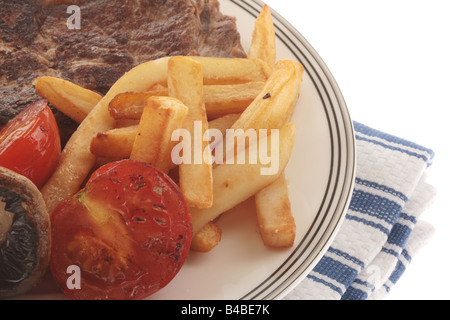 Frische, gesunde Sirloin Rindersteak mit Tomaten, Pilzen und Chips serviert auf einem Teller Isoliert gegen einen weißen Hintergrund mit Keine Personen Stockfoto