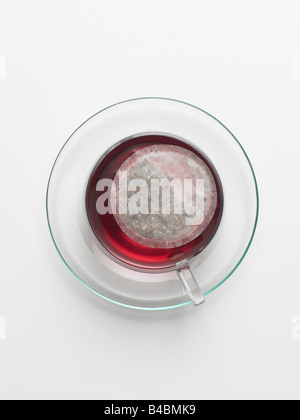 Kräuter Teebeutel in Glas-Tasse und Untertasse Stockfoto