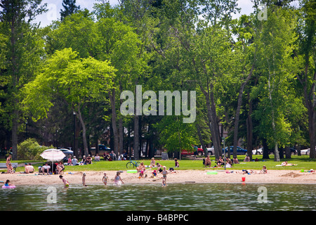 Entspannte Urlauber am Sandstrand von Clear Lake in Wasagaming, Riding Mountain National Park, Manitoba, Kanada. Stockfoto