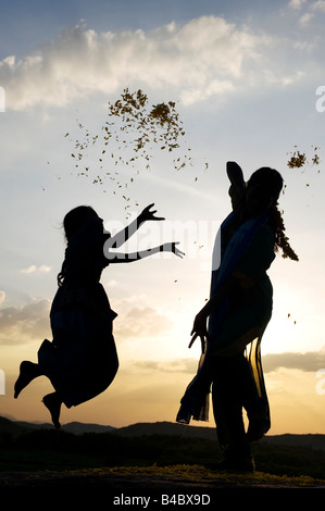 Zwei indische Schwestern Durchführung einer hinduistischen frommen Tanzes auf einem Felsen bei Sonnenuntergang Silhouette. Andhra Pradesh, Indien Stockfoto