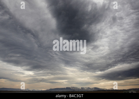 Bewölkter Himmel mit Bergen, Ost-Island Stockfoto